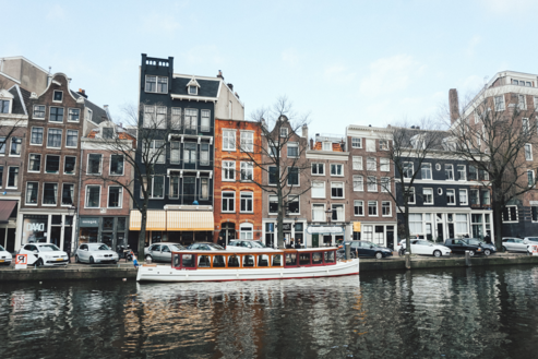 Boat in front of canal houses in Amsterdam